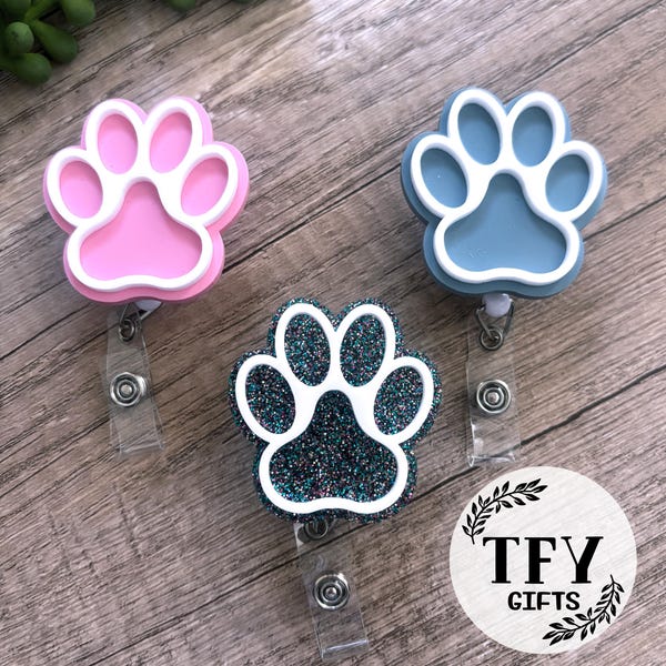 Glitter paw print badge reels in pink, blue, and teal